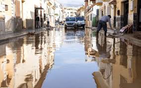 A puréed and simmering carrot soup in a pot with a spoon