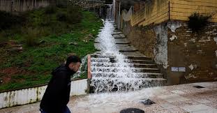 A puréed and simmering carrot soup in a pot with a spoon
