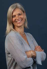 A puréed and simmering carrot soup in a pot with a spoon