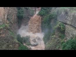 A puréed and simmering carrot soup in a pot with a spoon